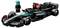 Modèle Lego d'une voiture de Formule 1 peinte en noir, vert et rouge, à côté d'une figurine Lego portant une combinaison de course noire.