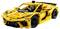 Voiture miniature jaune construite à partir de blocs de construction, avec des roues noires, un design sportif et des parties mobiles ; ressemblant à une voiture de course.
