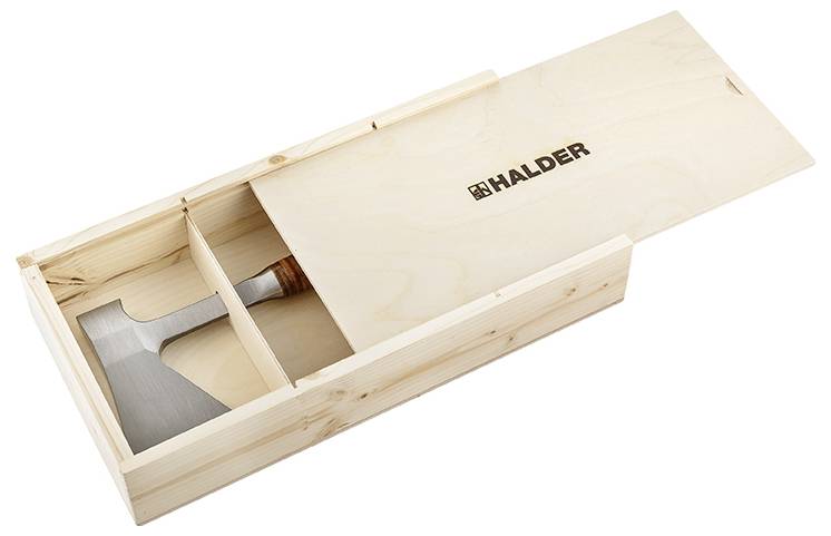 Caisse en bois avec couvercle coulissant, partiellement ouverte, montrant une hache avec manche en bois. Le logo 'HALDER' est visible sur le couvercle.