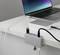 Un ordinateur portable avec son écran ouvert est posé sur une table. Un hub USB est connecté et une clé USB ainsi que des câbles sont branchés.