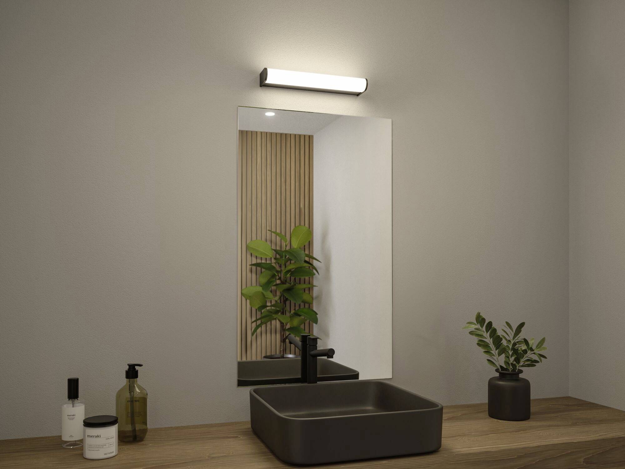 Une salle de bain moderne avec un comptoir en bois, un lavabo rectangulaire, un grand miroir, une lampe murale et une plante verte en arrière-plan.