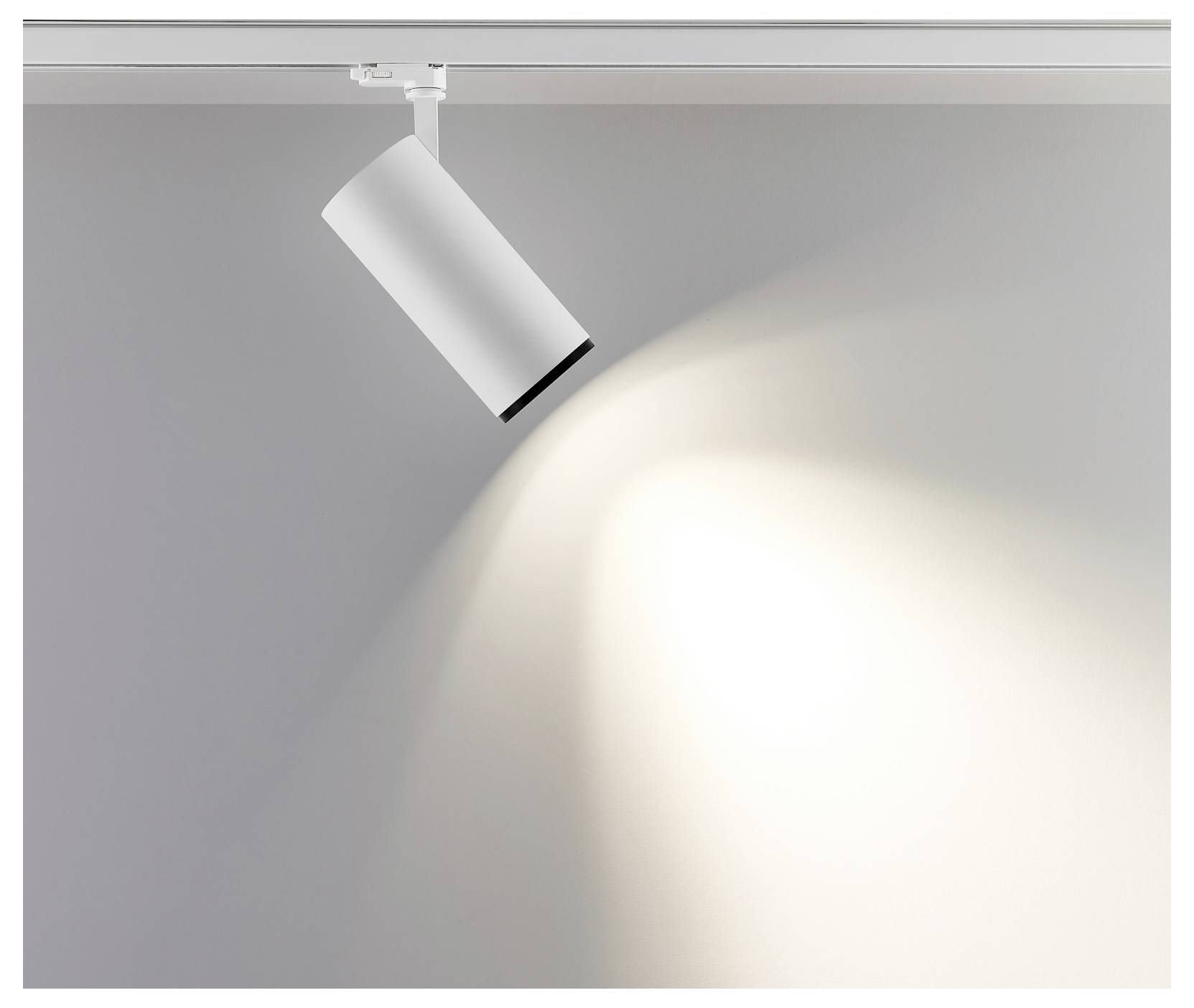 Spot sur rail blanc projetant un faisceau lumineux intense sur un mur gris.