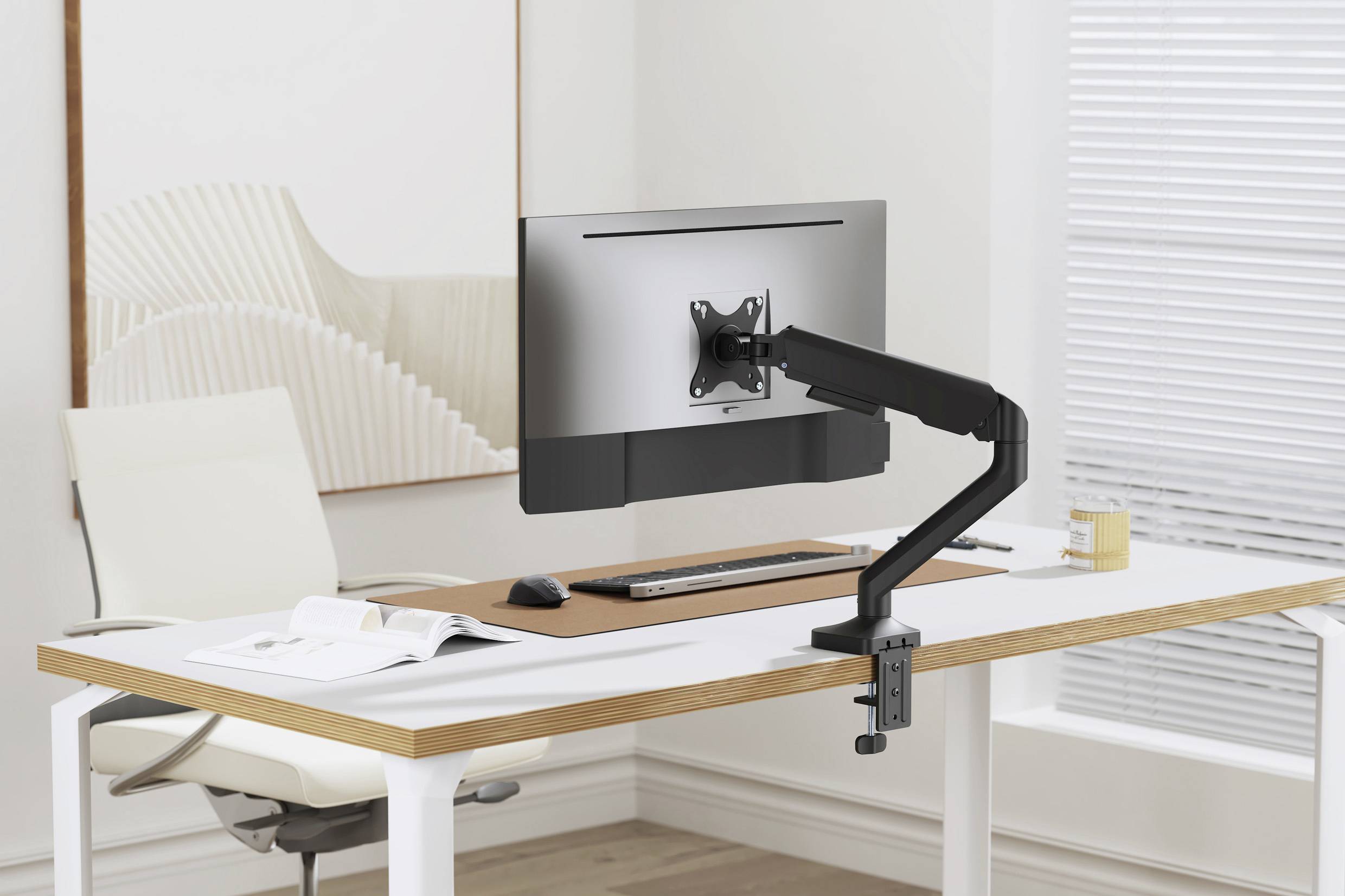 Un espace de travail moderne et bien rangé avec un bras support de moniteur réglable et un écran plat sur un bureau blanc.