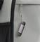 Une clé USB est accrochée à un sac à dos gris.