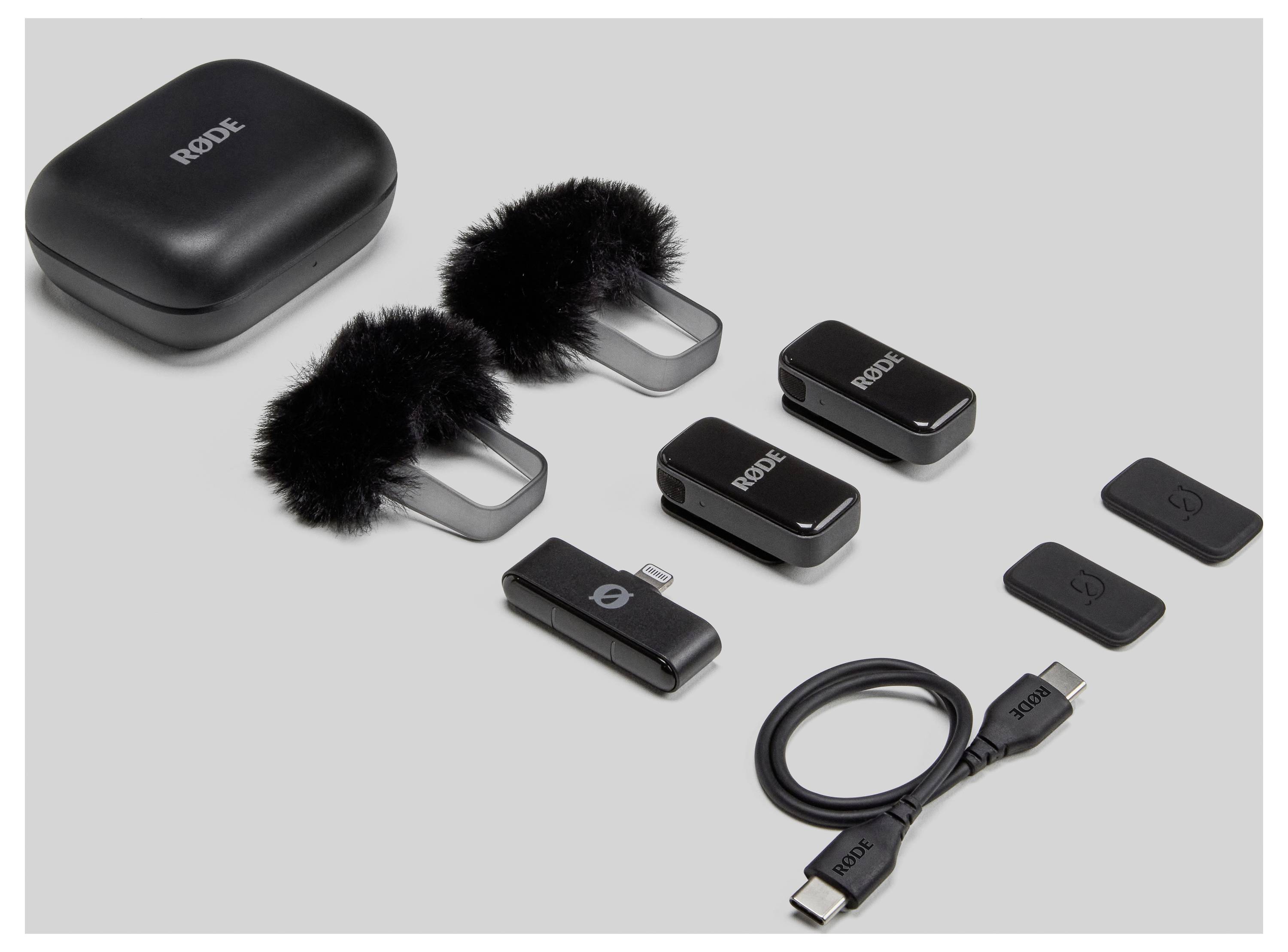 Ensemble de microphones sans fil composé d'un étui de chargement, deux microphones avec bonnette pare-vent, deux récepteurs et un câble USB-C sur fond gris.