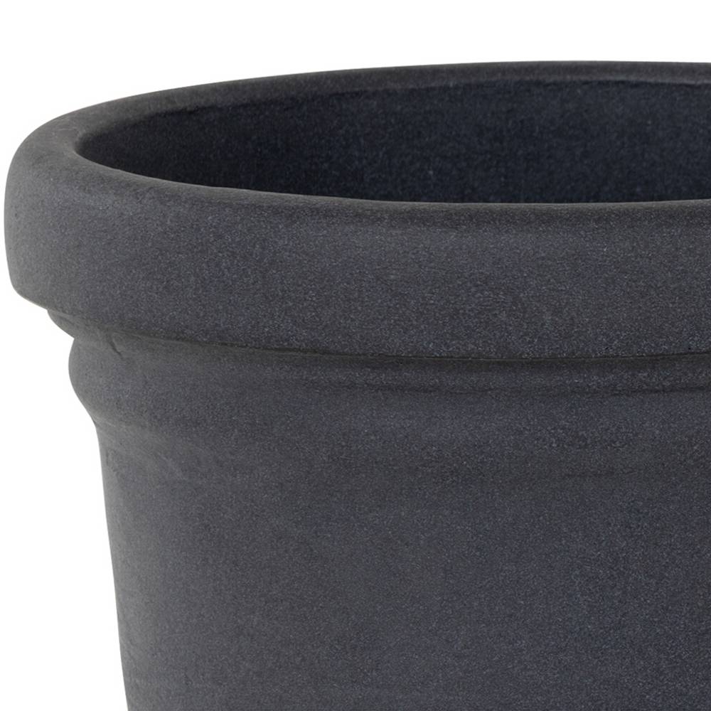 Un grand pot de fleurs en céramique, vide et sombre.