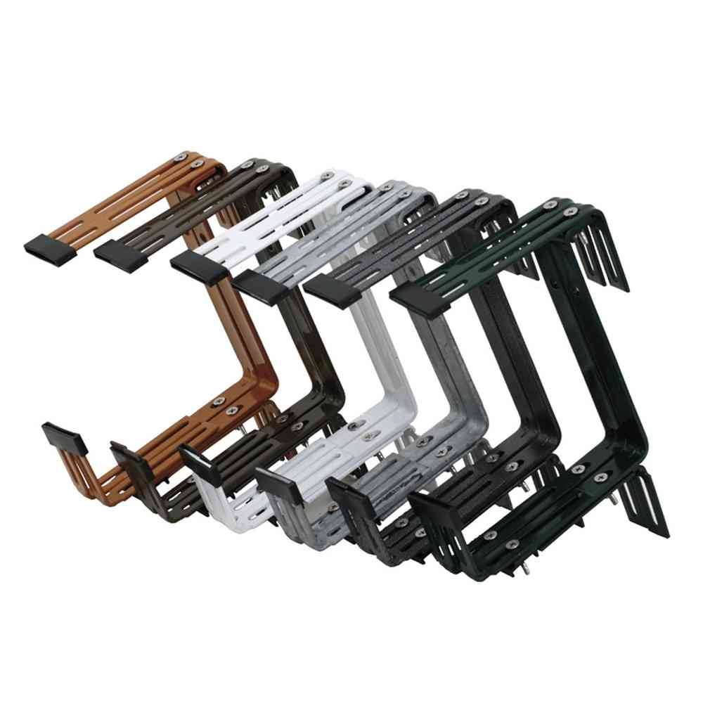 Plusieurs équerres métalliques de différentes couleurs, empilées en rangées, utilisées pour la fixation ou le support dans les constructions.