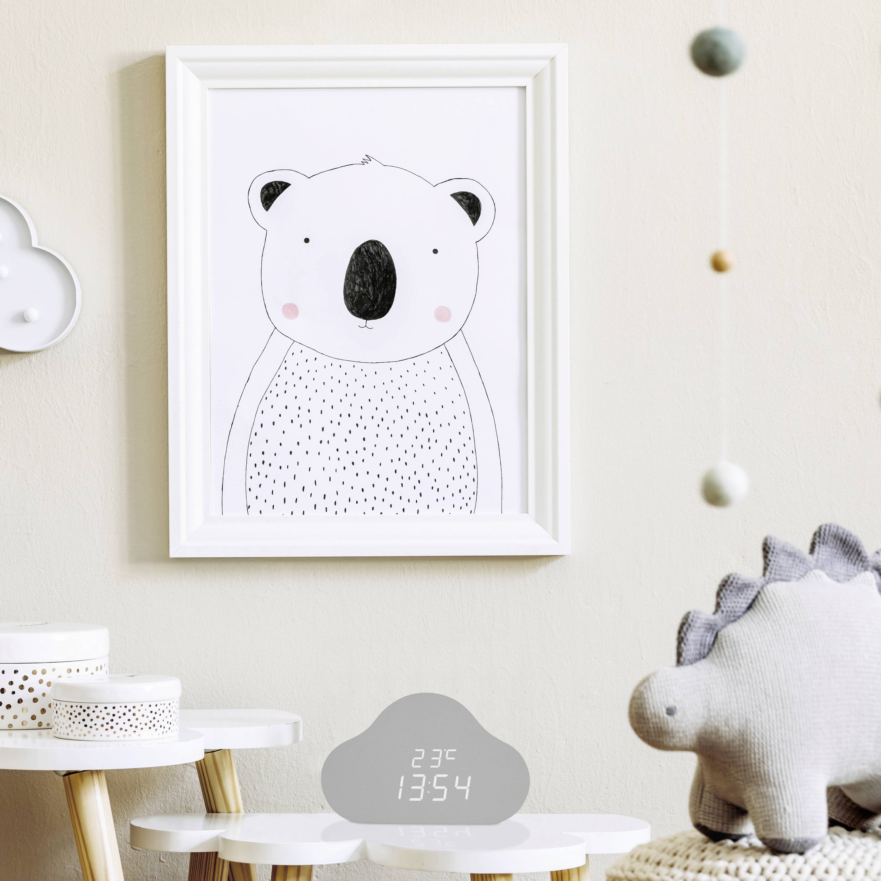 Une chambre d'enfant avec une adorable image de koala sur le mur, des jouets sur une table, et un affichage de température indiquant '23°C'.