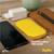 Étui en silicone jaune sur une table à côté d'un téléphone portable, d'un chargeur et d'un stylo. Texte dans l'image : « Housse en silicone adaptée aux voyages ». Nom de marque : « Aqiila ».