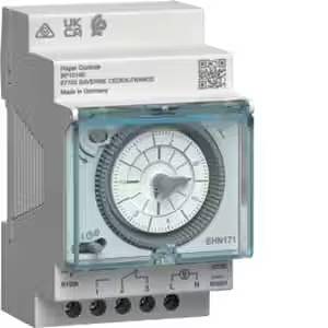 Un dispositif de commutation gris et rectangulaire avec un cadran analogique au centre. Des étiquettes portant un texte technique sont apposées en haut.