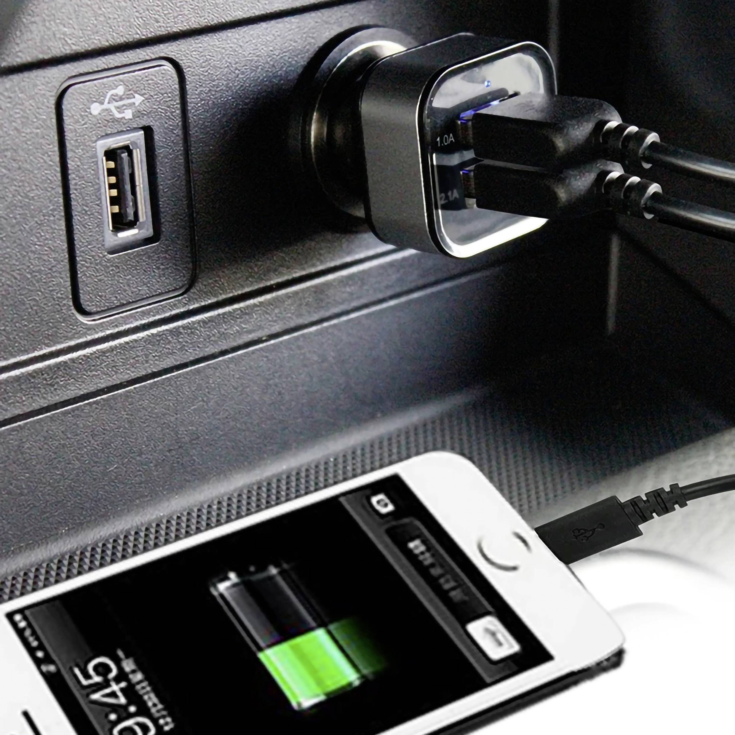 Un chargeur de voiture USB est branché dans la prise allume-cigare de la voiture. Un smartphone est en train de se charger à l'aide d'un câble connecté au chargeur.