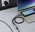 Un smartphone est connecté à un ordinateur portable via un câble USB, et une prise électrique se trouve sur la table.