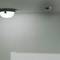 Plafonnier et détecteur de fumée installés sur un plafond blanc et sobre.