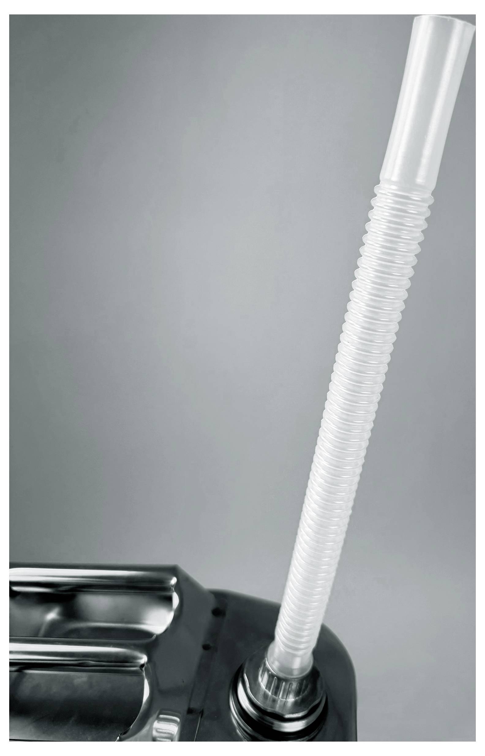 Un gros plan d'un tuyau d'aspirateur sur un fond gris, raccordé à un aspirateur métallique.