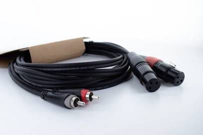 Un câble audio avec deux fiches RCA et deux fiches XLR sur fond blanc.
