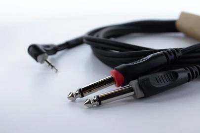 Deux câbles audio, l'un avec une fiche jack, l'autre avec des fiches rouge et noire. Posés sur un fond blanc.