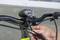 Une personne fixe une lumière sur un guidon de vélo à l'aide d'un tournevis.