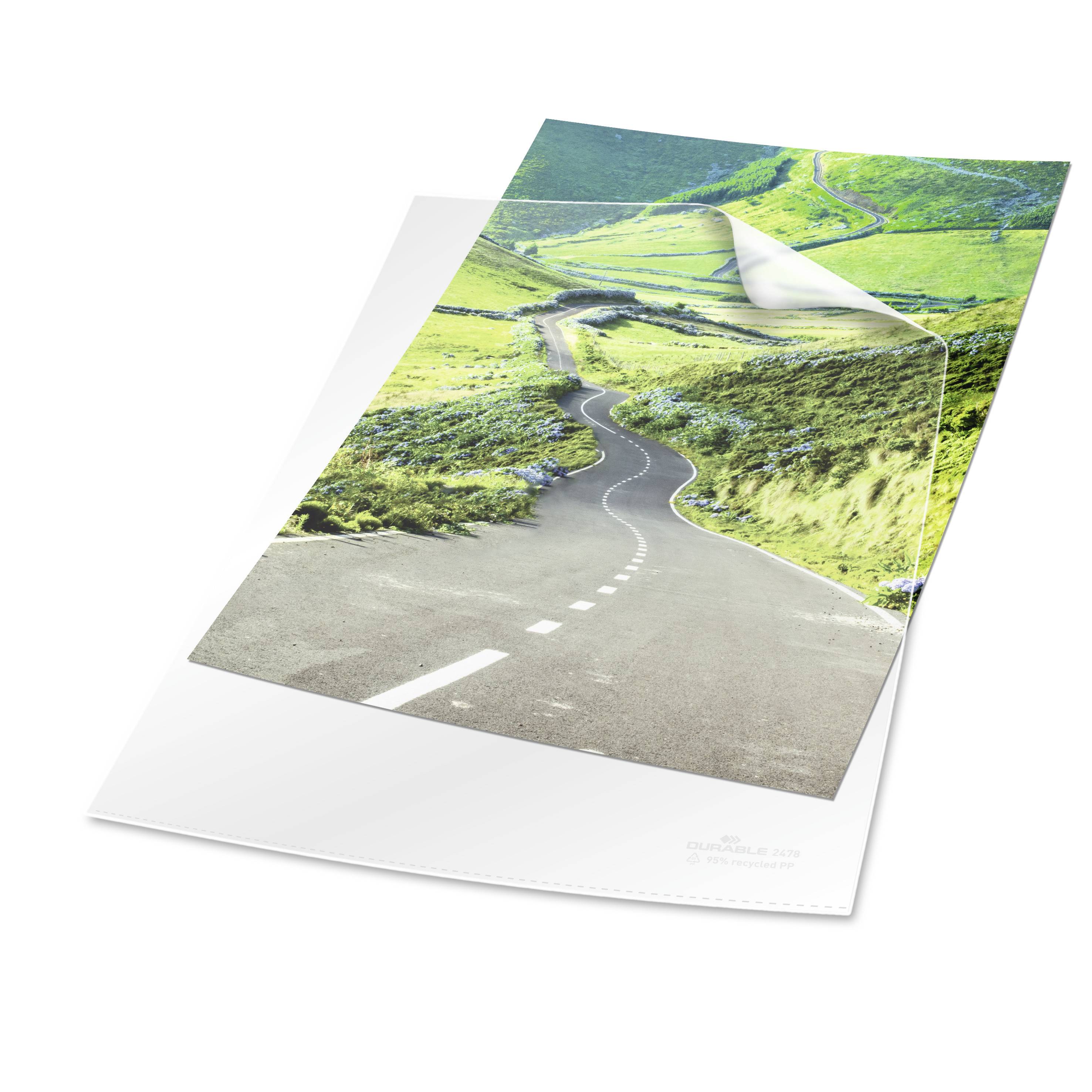 Une image d'une route de campagne traversant un paysage de collines verdoyantes. Le ciel est clair et bleu, transmettant une scène paisible.