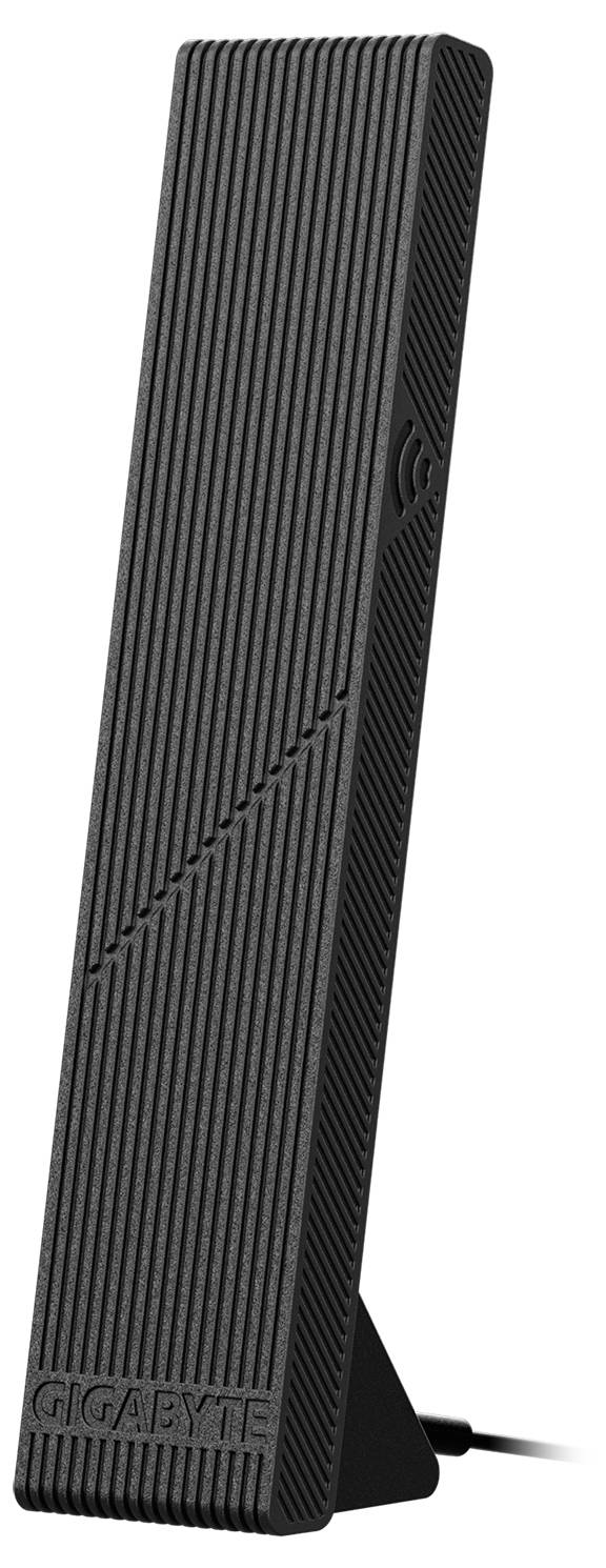 Antenne WLAN externe noire et étroite avec un design rainuré, posée sur une table, le nom de marque 'GIGABYTE' visible en bas.