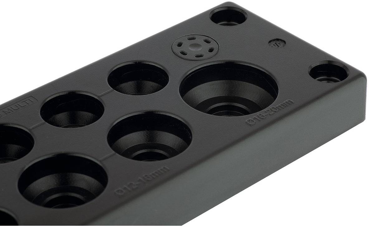 Passe-câbles multifonctions en plaque de plastique noir avec différentes tailles de perforations pour le guidage des câbles.
