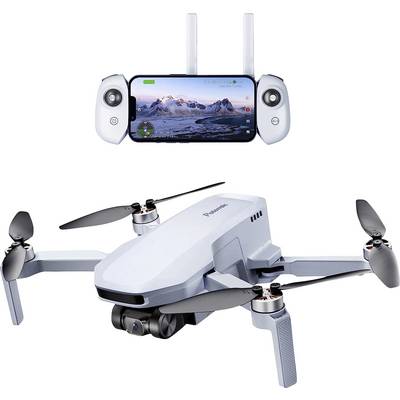 Un drone blanc à quatre rotors et caméra, à côté d'une télécommande avec un écran affichant un paysage montagneux.