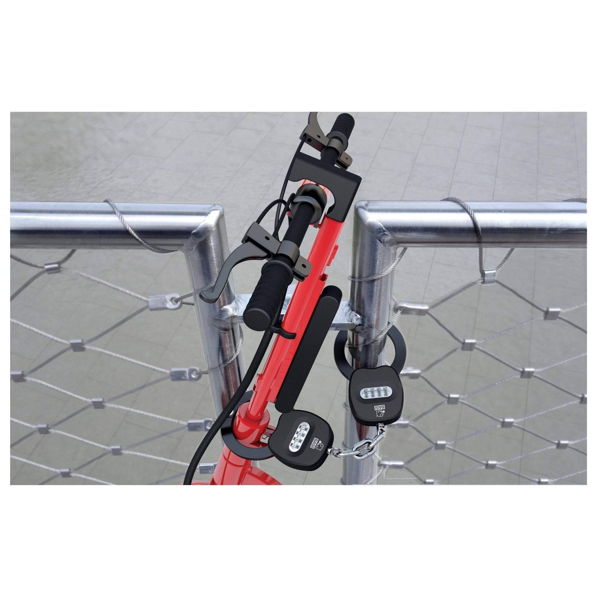 Vélo rouge verrouillé avec un cadenas à code sur une clôture métallique. Le vélo est garé au-dessus de l'eau, en bordure de rivière.