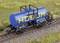 Un wagon-citerne bleu sur un rail de train miniature. Sur le réservoir est inscrit le nom 'HOEBUM' en lettres jaunes.