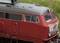 Une locomotive rouge de la Deutsche Bahn, vue rapprochée latérale de la cabine de conduite, avec des détails distincts des fenêtres et des structures.