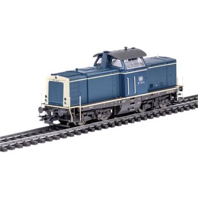 Un train miniature d'une locomotive diesel à l'échelle H0, peint en bleu avec des détails blancs et noirs, roule sur des rails.
