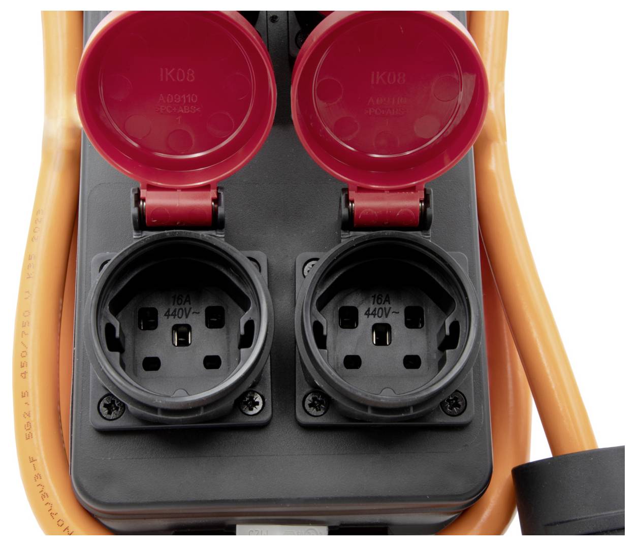 Gros plan sur deux prises électriques noires avec couvercle rouge sur un enrouleur de rallonge orange.