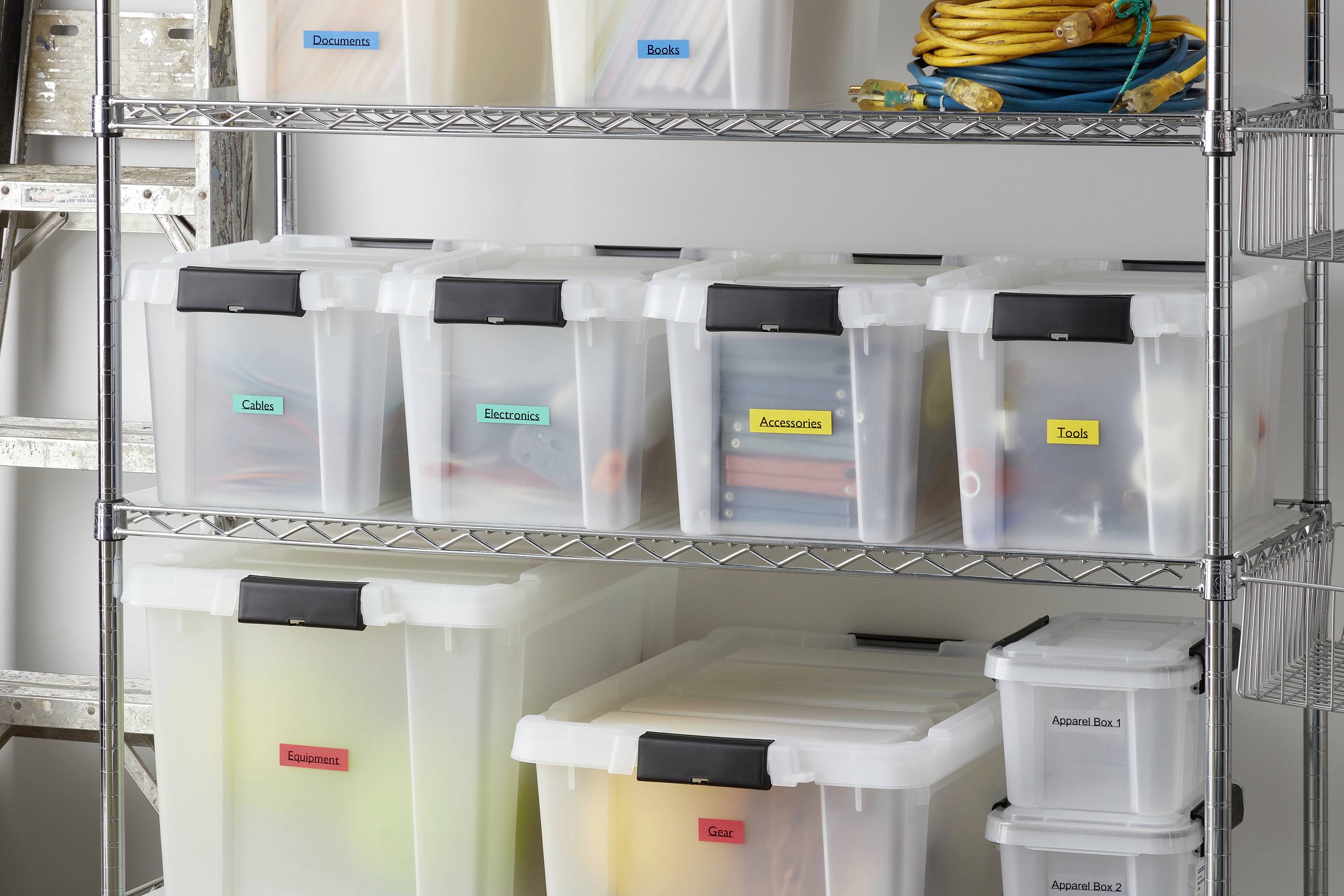 Boîtes transparentes sur une étagère métallique, étiquetées 'Câbles', 'Électronique' et 'Outils', pour un rangement organisé.