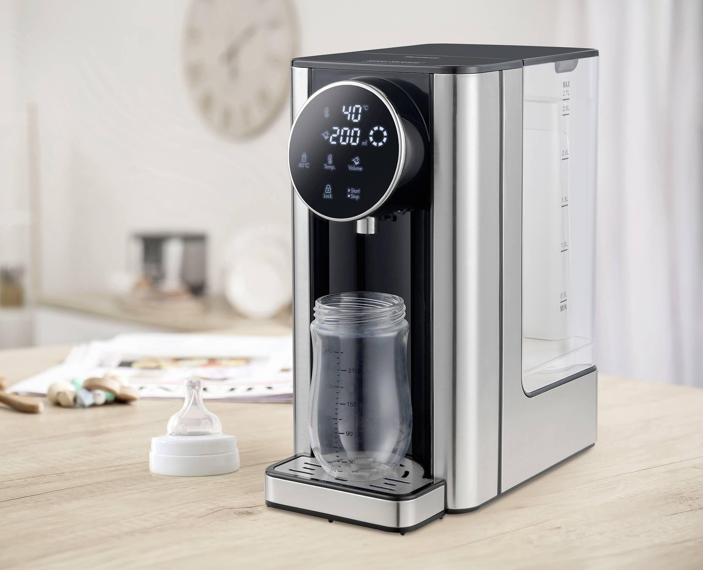 Une bouilloire avec un affichage numérique indique 40°C. Un verre est placé en dessous, rempli d'eau chaude. En arrière-plan, on aperçoit une cuisine.