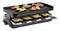 Un grill à raclette avec huit petites poêles, remplies de fromage fondu. Sur la plaque de grill, des crevettes, des saucisses et des légumes sont en train de griller.