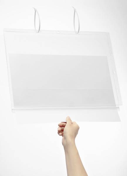 Une main tient une pochette en plastique transparent avec deux crochets blancs en haut, sur un fond blanc.