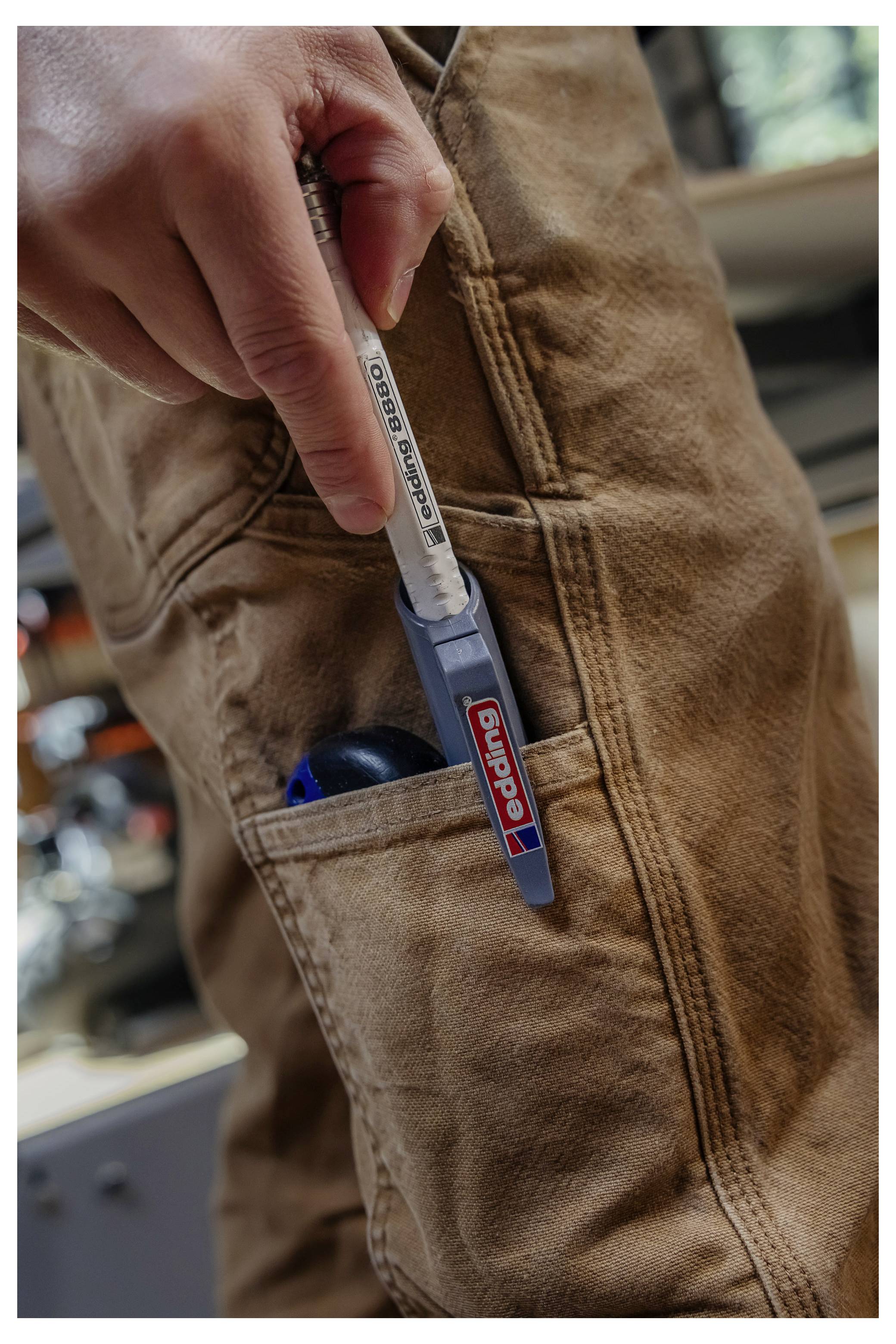 Main tenant une sonde thermométrique ThermoPop insérée dans la poche d'un tablier marron.