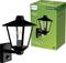 Une lampe murale extérieure noire de style lanterne à côté d'un emballage vert Philips ; design résistant aux intempéries pour une durabilité accrue.
