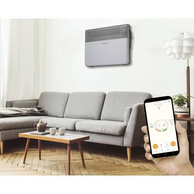 Un salon avec un canapé gris, une table et un tapis. Une personne tient un smartphone affichant le contrôle d'un climatiseur.