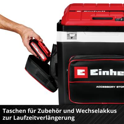 Un homme place une boîte d'accessoires rouge dans un sac noir Einhell à fermeture éclair. Texte en bas : 'Sacs pour accessoires et pièces interchangeables'.