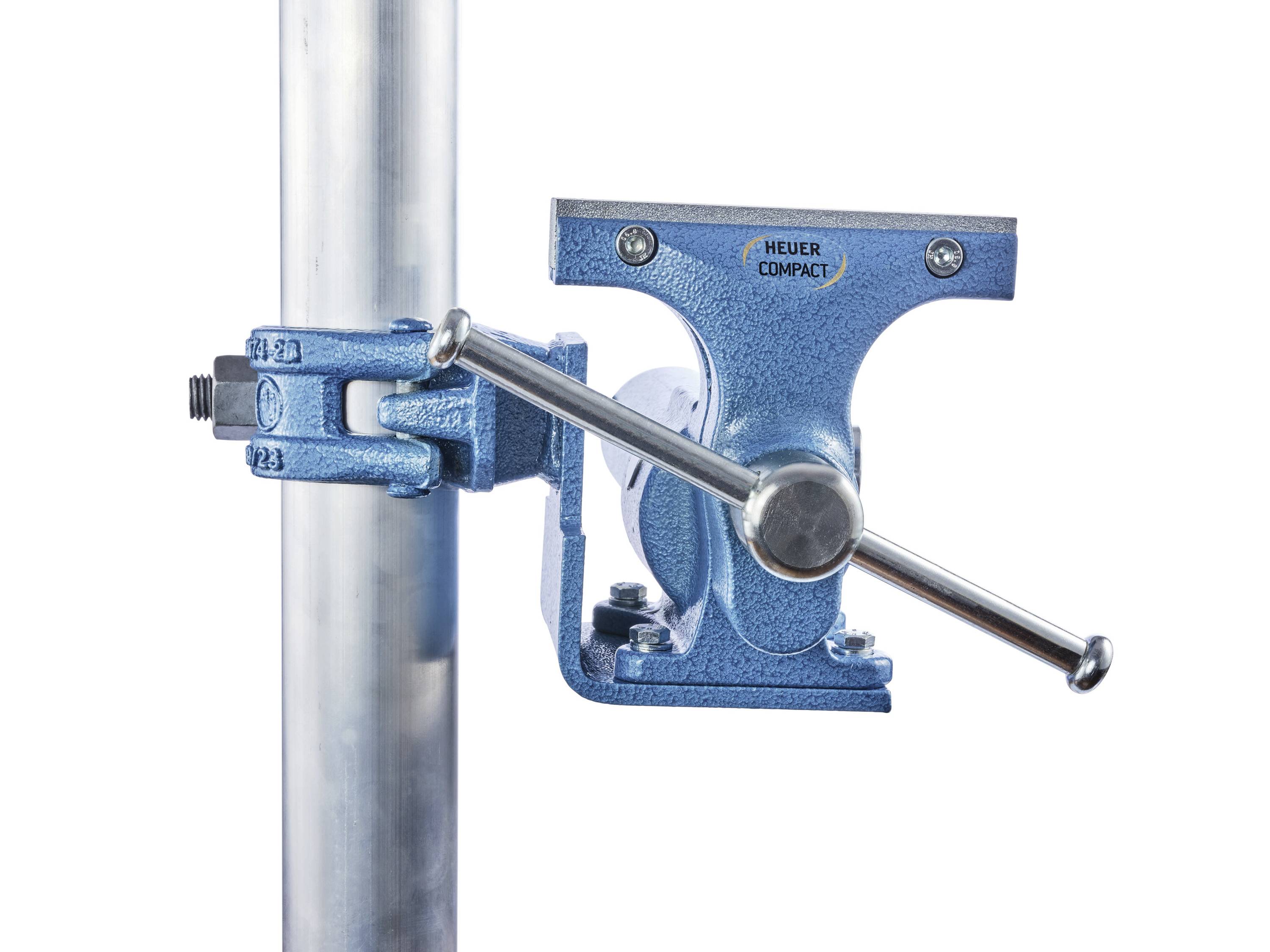 Un étau bleu de la marque HEUER Compact est fixé à un tube métallique vertical. Il illustre une utilisation en atelier.