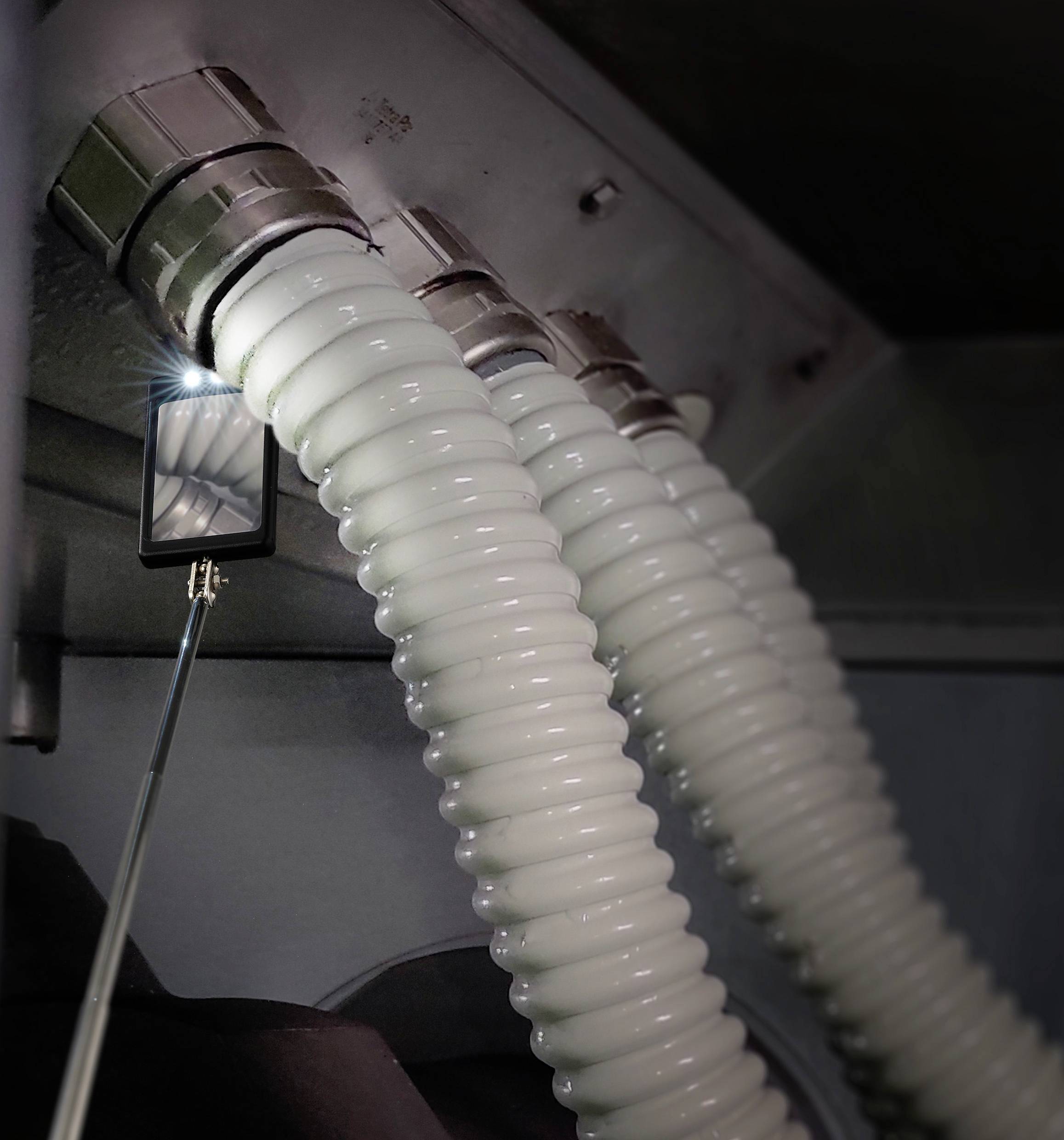 Trois tuyaux blancs connectés à une surface métallique. Un miroir sur une tige éclaire l'intérieur.