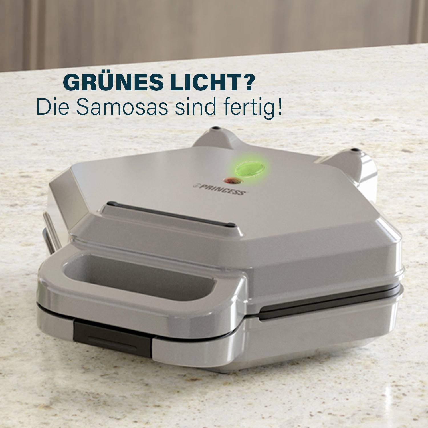 Un fabricant de samosas argenté avec un voyant vert est posé sur un plan de travail. Texte au-dessus : « Feu vert ? Les samosas sont prêts ! »