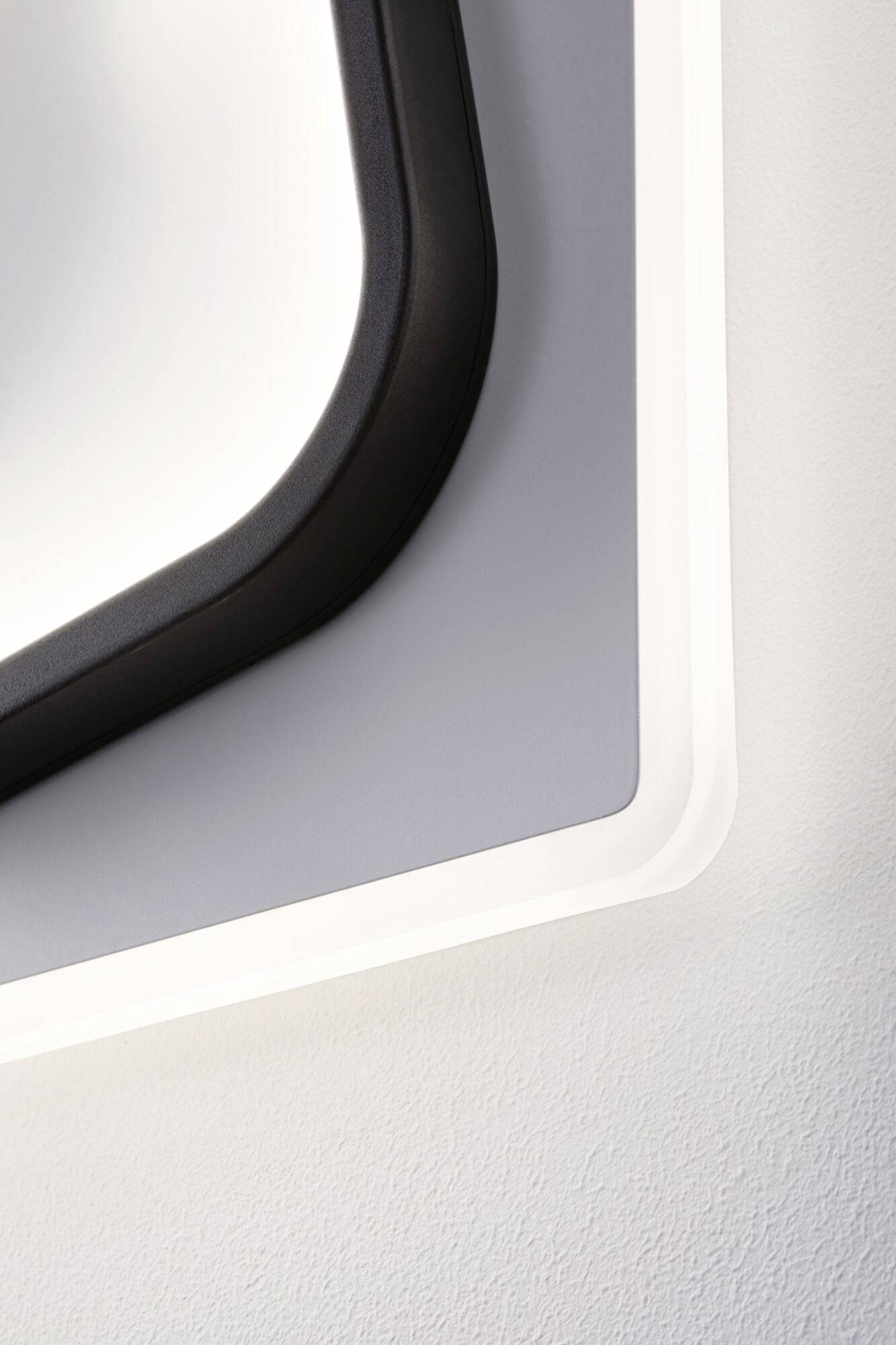 Des formes géométriques abstraites noires et blanches sur un mur blanc, représentant un style minimaliste et moderne.