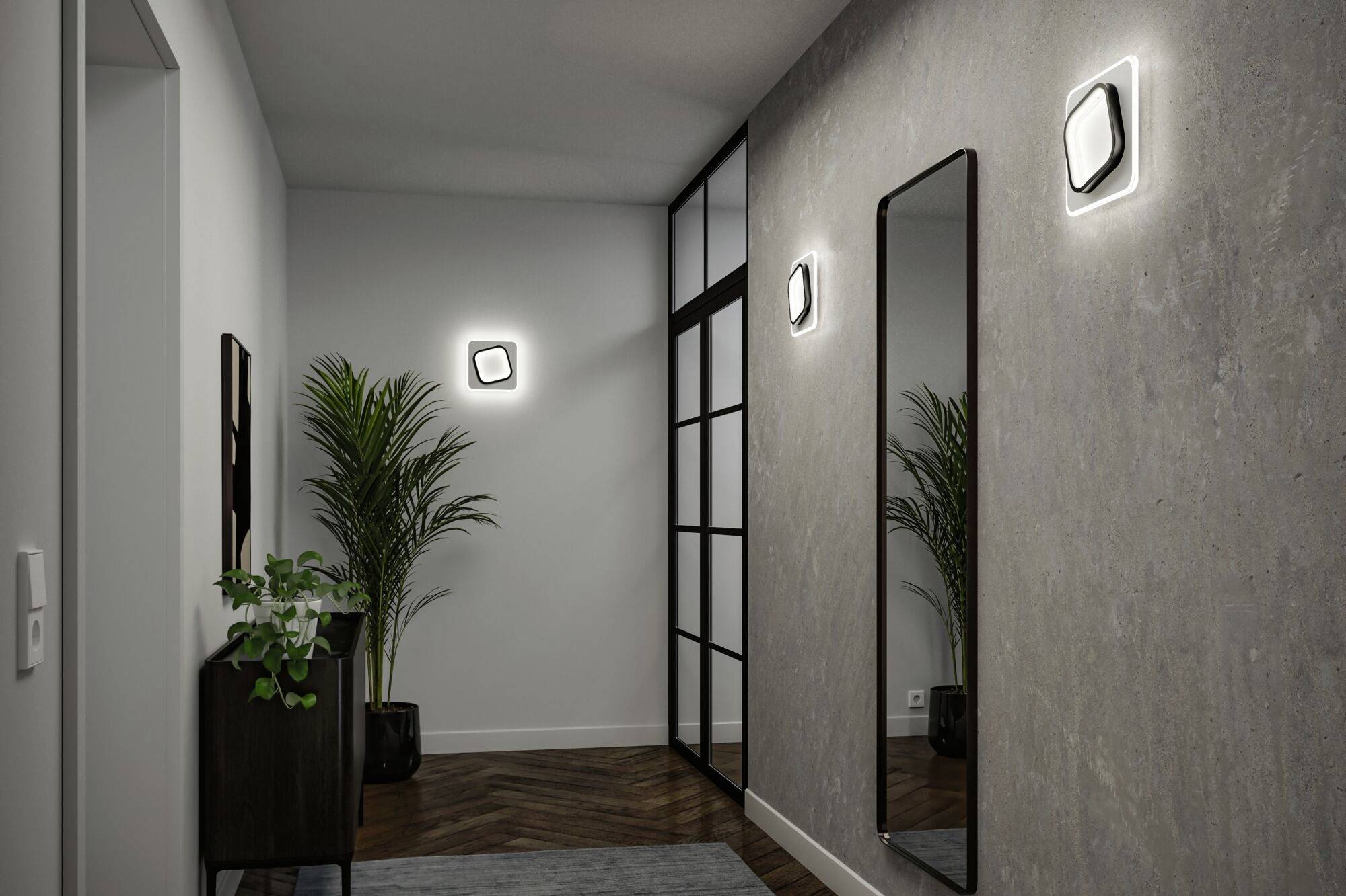 Entrée moderne avec un grand miroir, deux appliques murales et des plantes en pots. Un parquet en bois foncé et des murs gris créent une ambiance élégante.