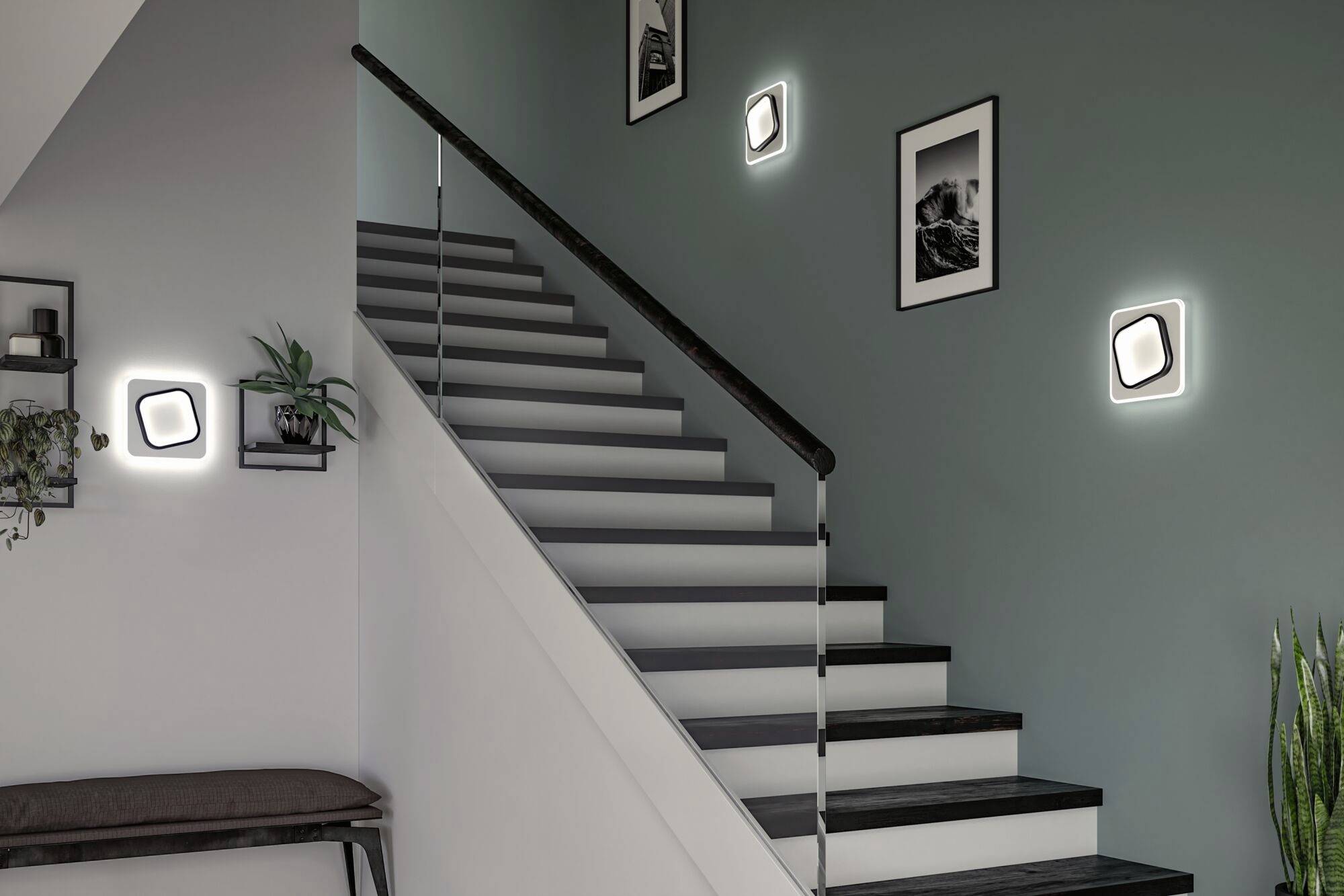 'Cage d'escalier avec garde-corps en verre, mur vert, fresques décoratives et appliques murales carrées lumineuses.'