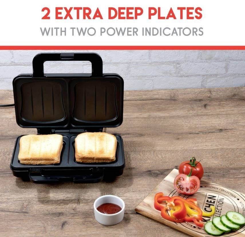 Un sandwich-maker avec deux sandwichs chauds à l'intérieur. À côté, des tomates et des poivrons coupés sont disposés sur une planche en bois.