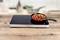 Une plaque de cuisson à induction à deux zones, sur laquelle repose une poêle rouge remplie de poivrons et de viande grillés, posée sur une surface en bois.