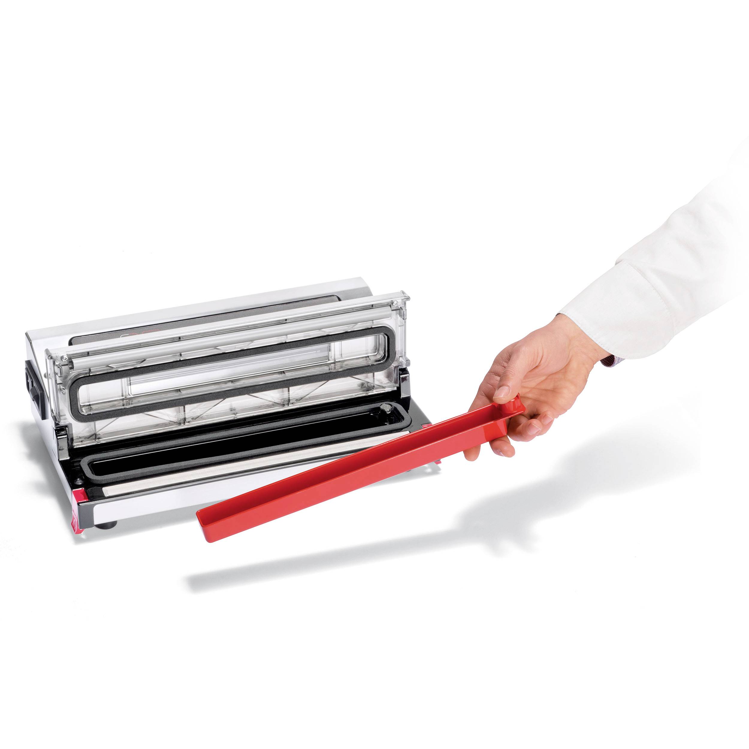Une personne montre une bande de plastique rouge qui est tirée d'une fente étroite d'une machine.