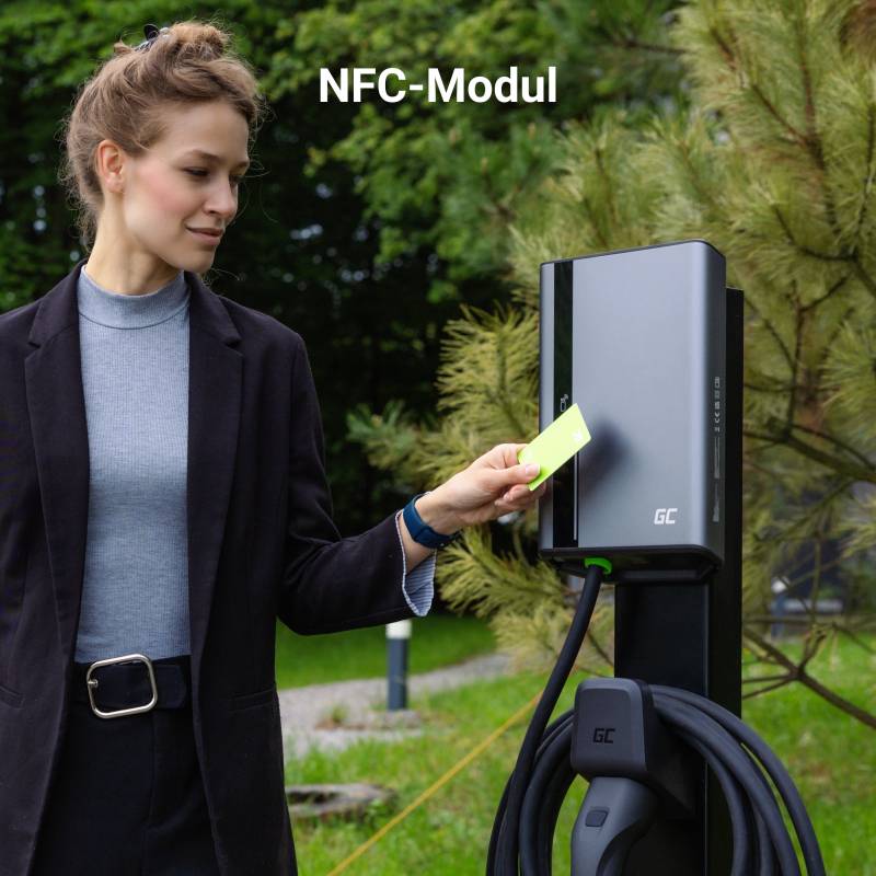 Une femme approche une carte d'un module NFC d'une borne de recharge. Des arbres sont visibles en arrière-plan.