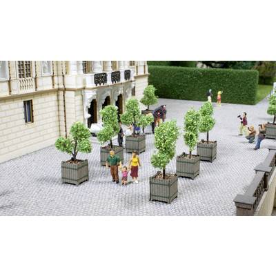 Un modèle miniature montre des personnes marchant dans une cour pavée entre des arbres en pot. Un couple tient les mains d'un enfant.