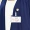 Une personne porte un badge nominatif sur lequel est inscrit 'Visitor' et 'E. Smith, Ingénieur'. Elle porte un haut bleu.